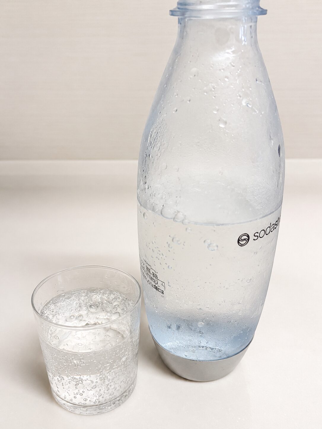 ソーダストリームで作った炭酸水を注いだグラスと専用ボトル。細かい泡が立っている